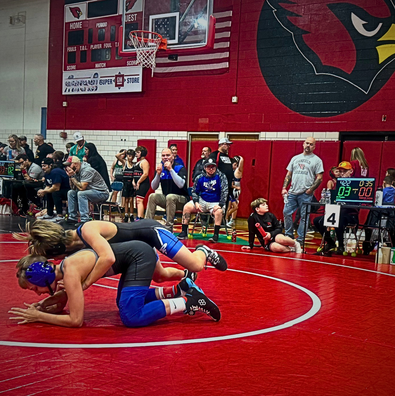 Youth wrestling match in progress with Snapdown digital scoring display showing score, time, and mat number